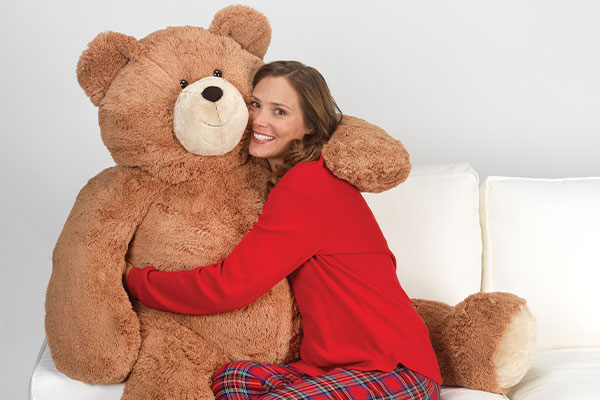 An image a model cuddling a 4-foot Big Hunka Love Bear