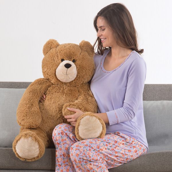 3' Hunka Love Bear - Seated golden brown bear with a female model in lavender pajamas on a sofa image number 4