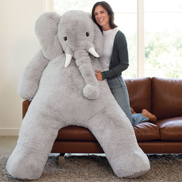 6' Giant Cuddle Elephant - Front view of seated grey plush elephant with model in a living room scene image number 6