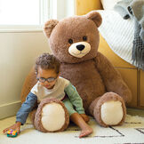 ' Cuddle Teddy Bear- Front view of seated mocha latte teddy bear in a bedroom scene with a child image number 0
