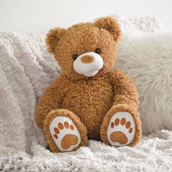 20" Bubba the Fuzzy Teddy Bear - Front view of seated almond brown bear in a bedroom scene