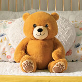 20" Hugsy the Teddy Bear - Front view of seated golden brown bear with light brown muzzle and embroidered foot pads in a bedroom scene image number 7