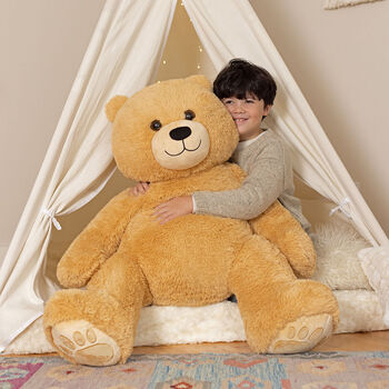 4' Boo The Loveable Big Teddy Bear - Seated light butterscotch brown bear in a bedroom scene with model