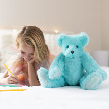 15" Blue Raspberry Lemonade Bear - Front view of jointed aqua blue bear with white paw pads in a bedroom scene with a model