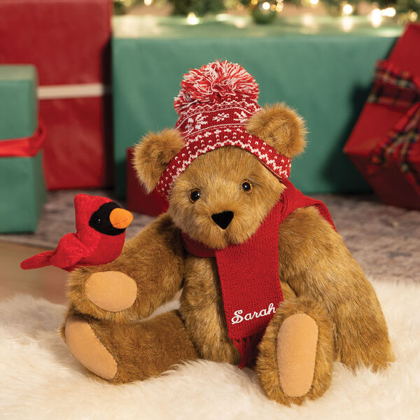 15" Season's Greetings Bear - Front view of seated jointed bear dressed in a knit red and white nordic patterned hat with red scarf and holding a red cardinal with Christmas gifts image number 1