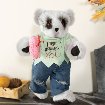 15" Zombie Love Bear - Front view of standing jointed bear with blackened eyes and embroidered scar and red heart tattoo on right arm wearing torn t-shirt and jeans. Bear is holding red heart and pink brain - gray fur